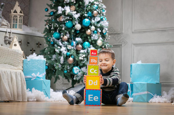 男孩在圣诞树上玩木<strong>字母积木</strong>