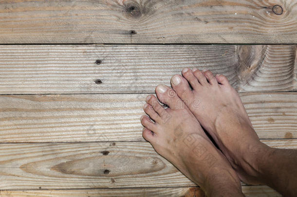 脚踩在旧的木地板背景上。