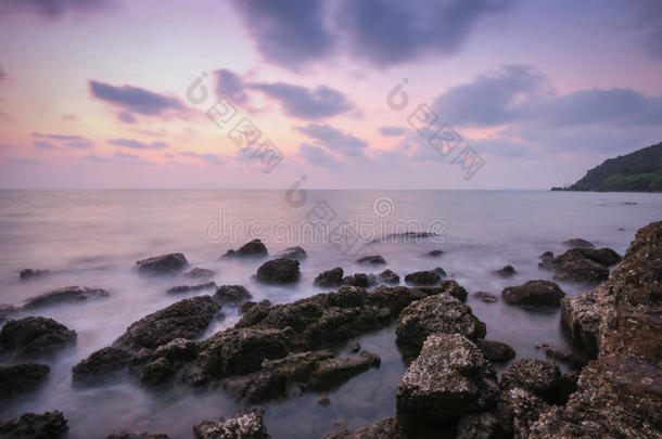 海岸黄昏的景象，长时间暴露在阳光下的岩石和波浪