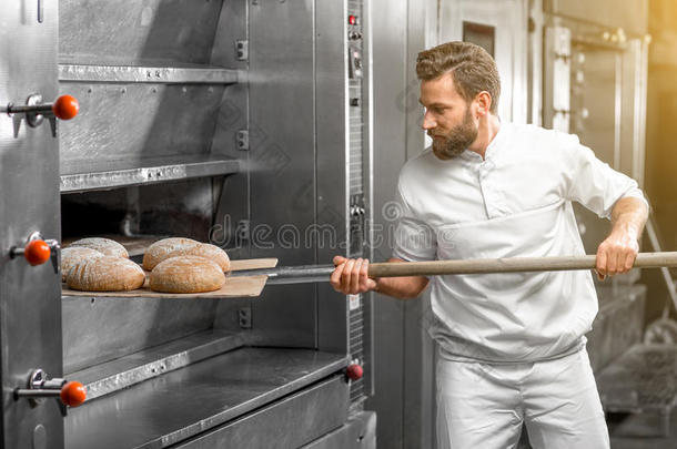 面包师从烤箱里拿出来烤面包