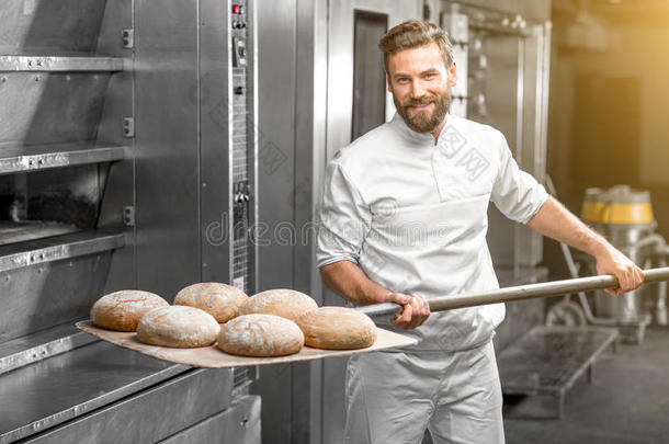 面包师从烤箱里拿出来烤面包