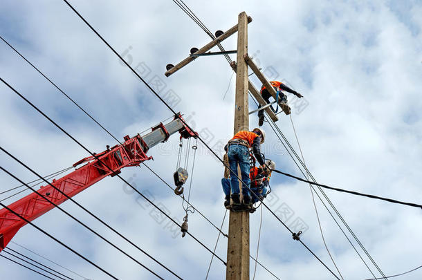 电工线路工修理工在电线杆上攀爬作业