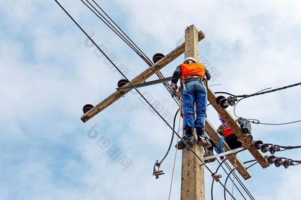 电工线路工修理工在电线杆上攀爬作业