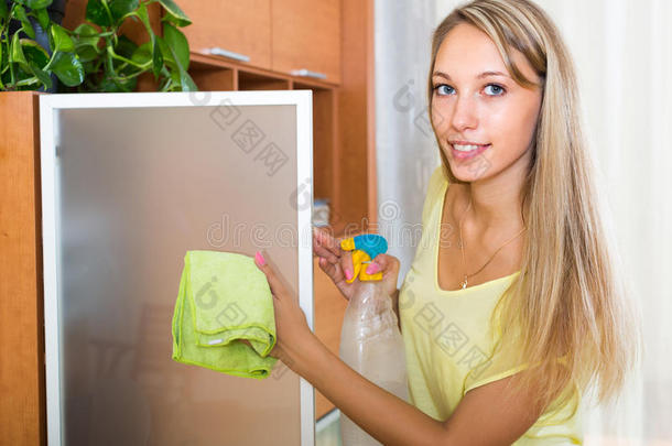 金发女人用洗涤剂清洗玻璃
