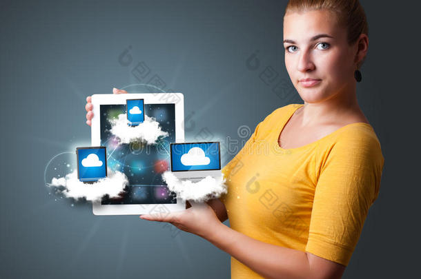 一个年轻的女人在云端拿着装有现代设备的平板电脑