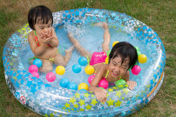 亚洲的中国小女孩在充气橡胶游<strong>泳池里玩耍</strong>