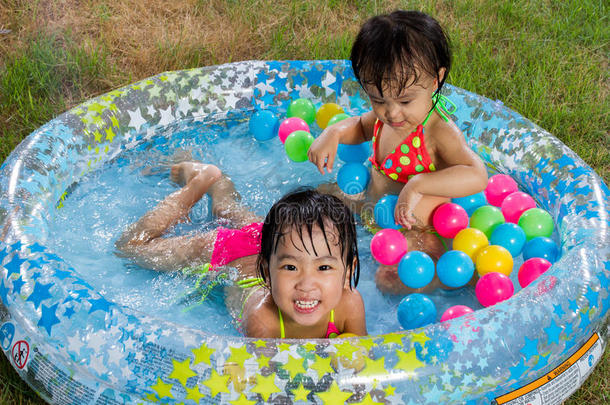亚洲的中国小女孩在充气橡胶游<strong>泳池里玩耍</strong>