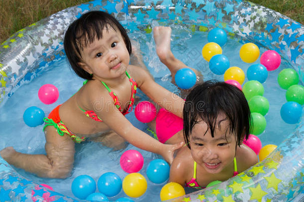 亚洲的中国小女孩在充气橡胶游泳池里玩耍