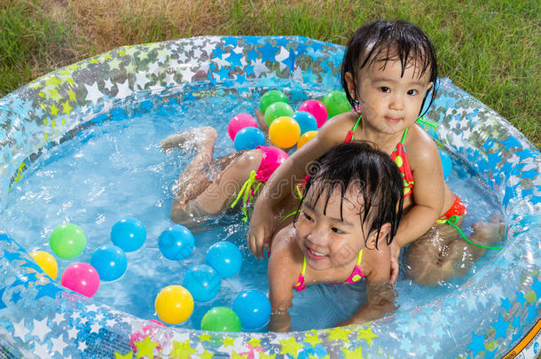 亚洲的中国小女孩在充气橡胶游泳池里玩耍