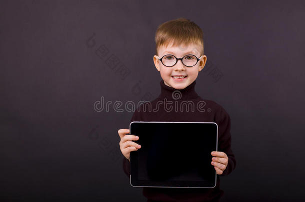 可爱的微笑男孩五年，手里拿着一块平板电脑