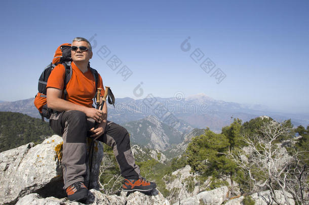 一个旅行者站在一座山的顶部，眺望大海。