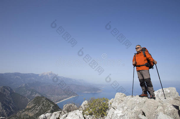 一个旅行者站在一座山的顶部，眺望大海。