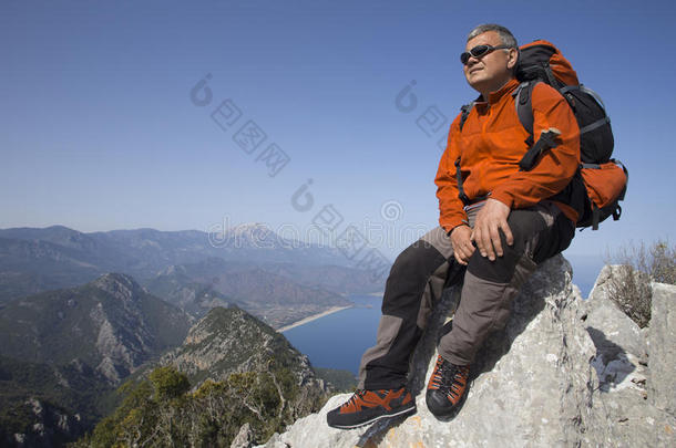一个旅行者站在一座山的顶部，眺望大海。