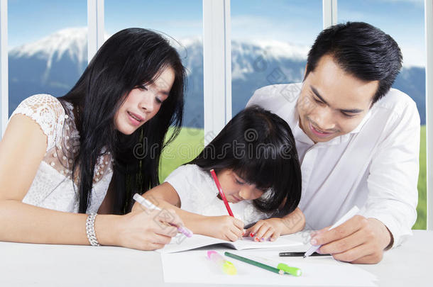 父亲和母亲帮助他们的孩子学习