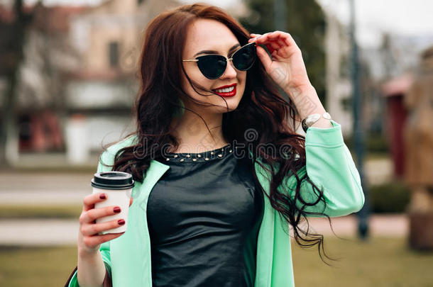 滑稽的模特戴着太阳镜，穿着一件绿色的<strong>小裙子</strong>，白色的背景。 年轻快乐的时尚生活方式肖像