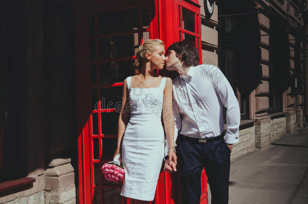 新娘和新郎在电话亭的背景上接吻。 <strong>旅</strong>游，<strong>旅游人</strong>的概念-快乐的老年夫妇