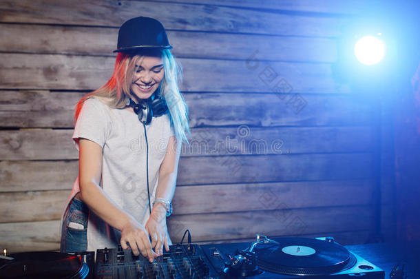 可爱的DJ女人在俱乐部聚会上玩音乐很开心