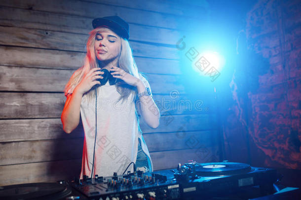 可爱的DJ女人在俱乐部聚会上玩音乐很开心