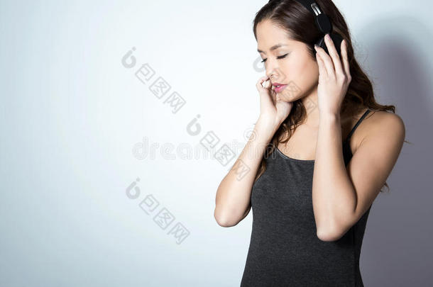 美丽的年轻女人用耳机听音乐