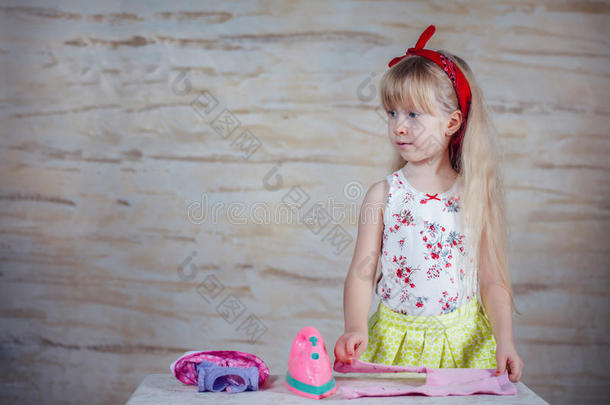 快乐的小女孩用玩具熨斗