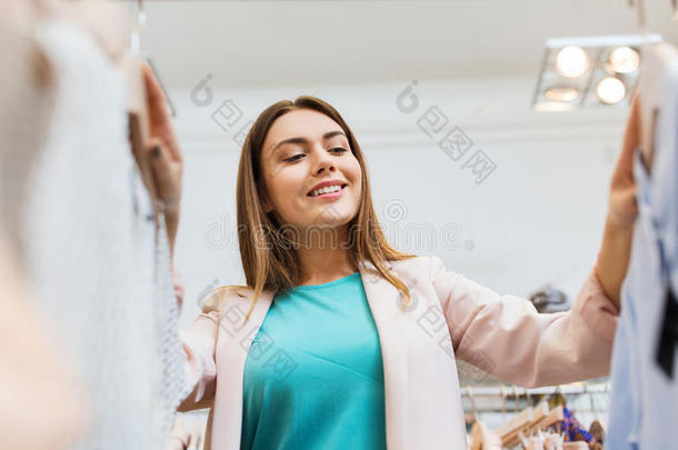 在商场挑选衣服的快乐年轻女人