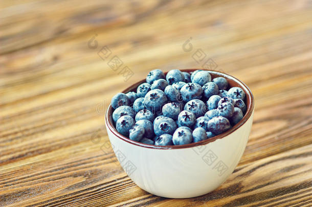 新鲜采摘的<strong>蓝莓</strong>在白色的碗里。 乡村餐桌上多汁新鲜的<strong>蓝莓</strong>。 木背景上的<strong>蓝莓</strong>。 <strong>蓝莓</strong>