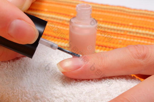 涂粉红色指甲油，修剪指甲的女人