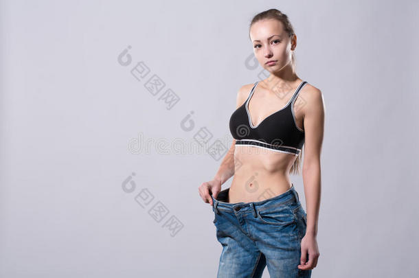 女孩穿着一条旧牛仔裤来展示她的<strong>减肥效果</strong>