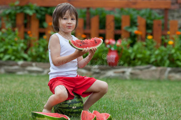 男孩，夏天在花园里吃西瓜