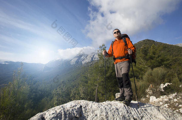 一个旅行者站在一座山的顶部，眺望大海。