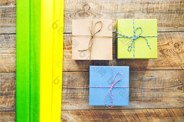 木制背景上带丝带的彩色礼品盒