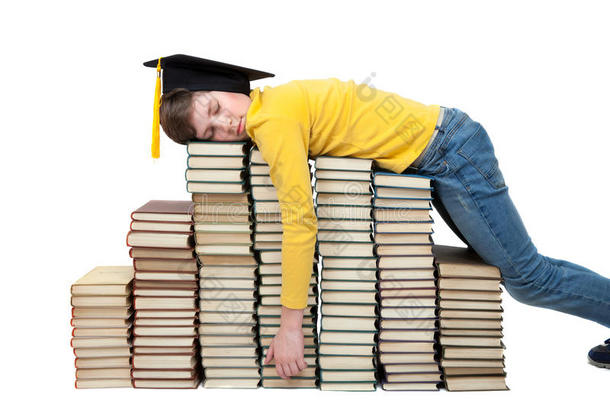 一个戴大学帽的男孩睡在一叠书上