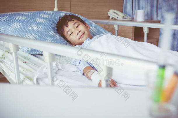 亚洲男孩躺在病床上，用<strong>输液</strong>泵静脉滴注。 复古风格。