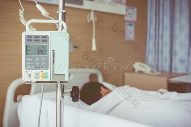 亚洲男孩躺在病床上，用输液泵静脉滴注。 复古风格。