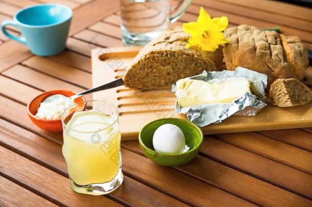 木制<strong>桌子</strong>上的面包、黄油、鸡蛋、果汁、黄油、奶酪（<strong>早餐</strong>）