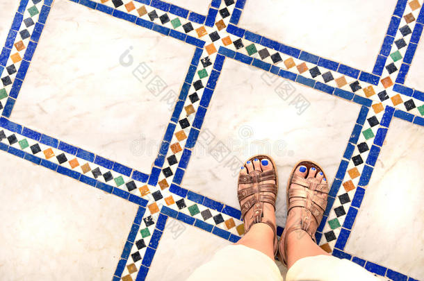 脚自拍从一个穿凉鞋的女旅行者在世界各地的旅游旅行的上部视图。 多色博物馆纪念品照片