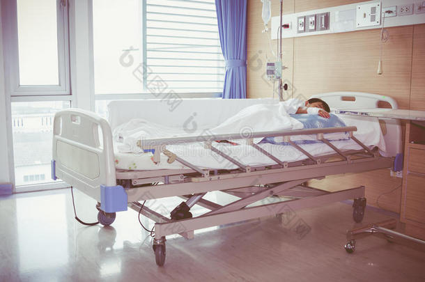 亚洲男孩躺在病床上用生理盐水<strong>静脉注射</strong>(Iv)。 健康