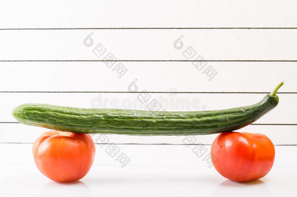 滑板和健康饮食的概念形象。 两个西红柿和黄瓜