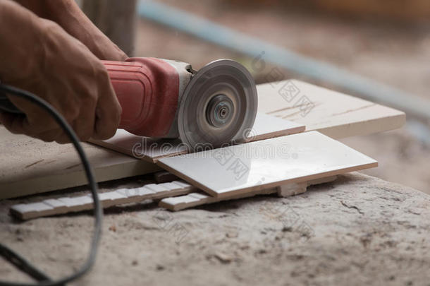 建筑工人用角磨机切割瓷砖
