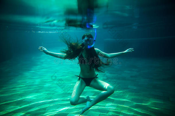 女孩用浮潜游泳水下游泳池