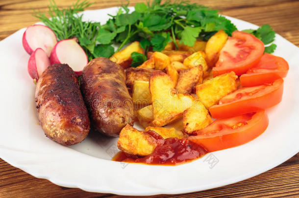 烤肉香肠与油炸土豆，切片西红柿，新鲜<strong>农产品</strong>和番茄酱在盘子在木制桌子上