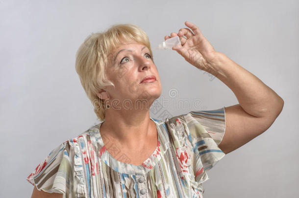 老妇人用药物治疗她的眼睛