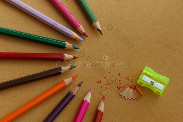 彩色铅笔排列成半圆形图案，铅笔刨花和黄色卷笔刀