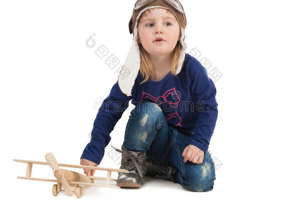 可爱的小女孩戴着木制飞机的飞行员帽子