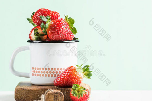 新鲜成熟的红色草莓，乡<strong>村风</strong>格的搪瓷杯，在乡村木板上，淡薄荷背景