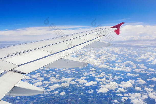 从飞机窗口看到的云、天空和飞机机翼