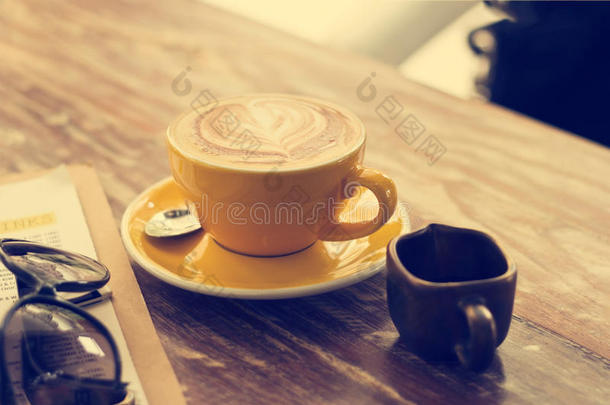 木桌上咖啡店的咖啡杯和蜂蜜糖浆