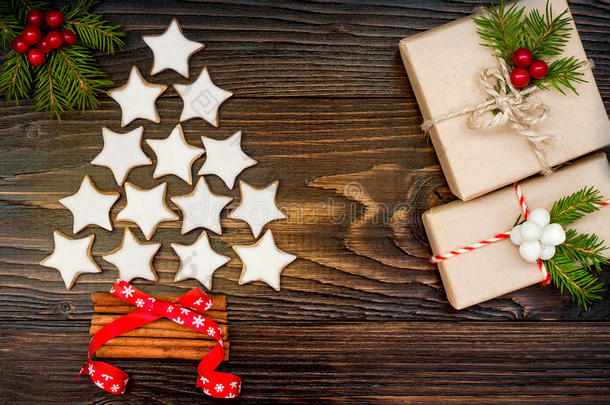 圣诞背景与姜饼饼干，礼物和冷杉树枝在旧木板上