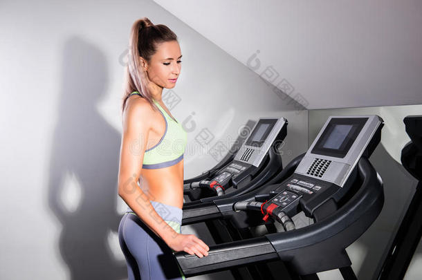 健身妇女在健身房跑步机上跑步