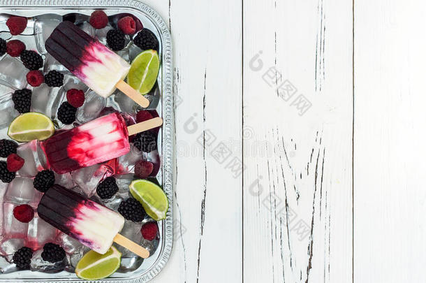 浆果香草冰棒-冰棒-在一个老式的银冰托盘在古老的乡村木制背景。